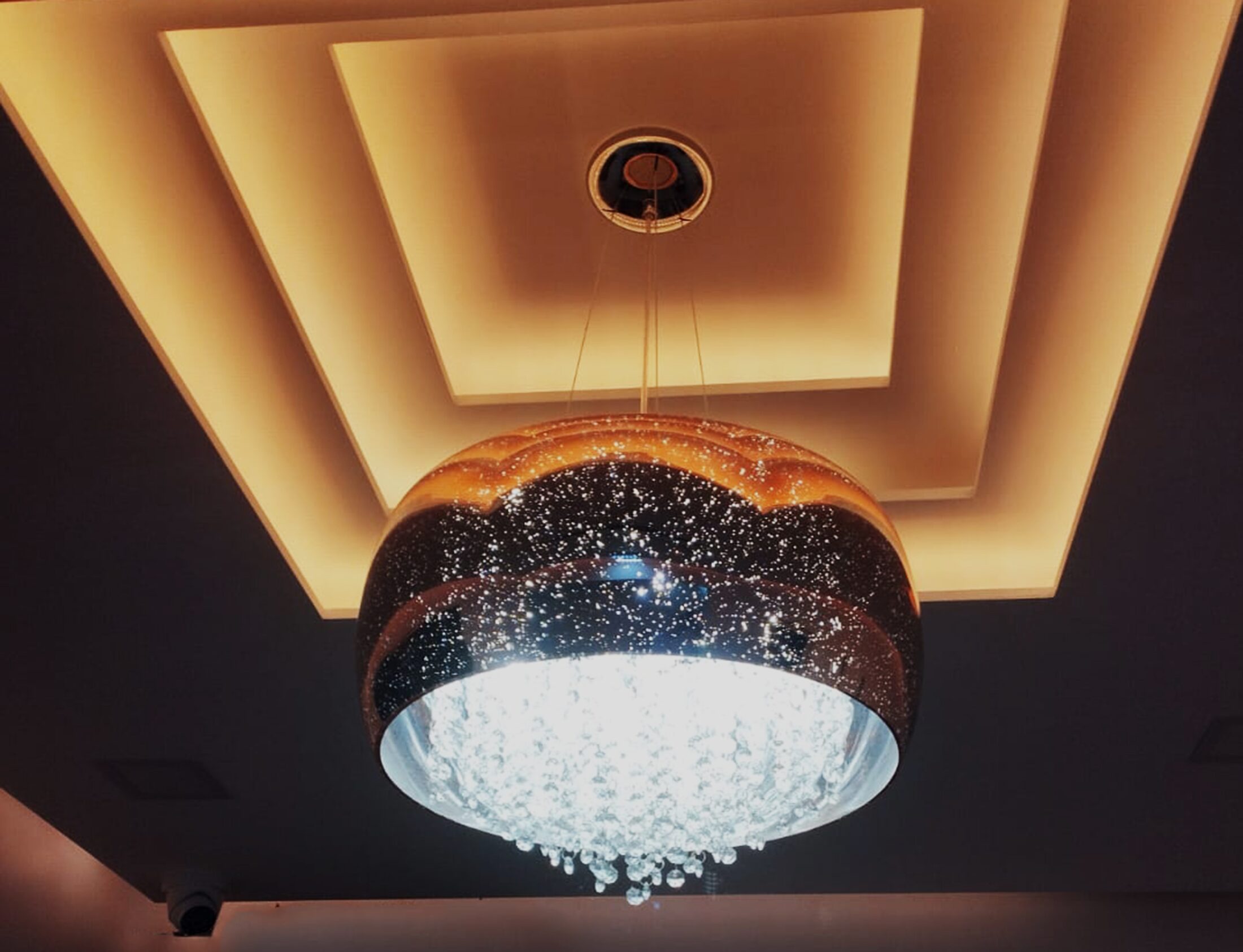 Lustre de cristal sobre o tecto trabalhado da sala Allgarbe